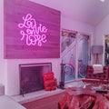 Close-up of the La Vie en Rose Neon Sign, glowing with pink and red hues, adding a romantic touch to any room.